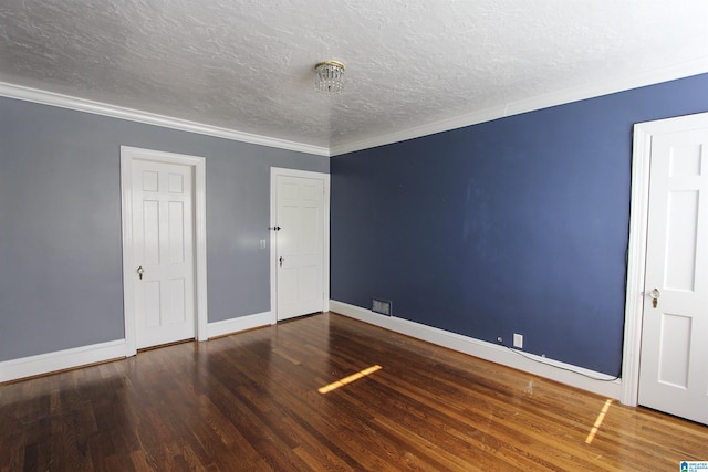 unfurnished bedroom featuring ornamental molding, dark wood finished floors, a textured ceiling, and baseboards