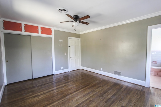 unfurnished bedroom with baseboards, dark wood-style flooring, visible vents, and crown molding