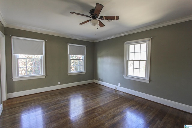 unfurnished room with a healthy amount of sunlight, ornamental molding, and dark wood finished floors