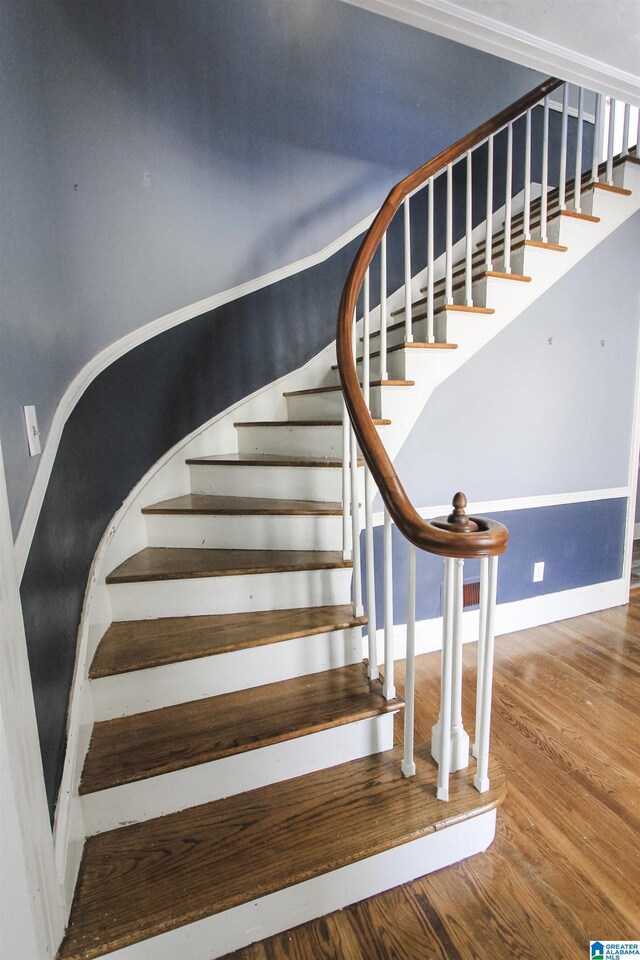 stairway with wood finished floors and baseboards