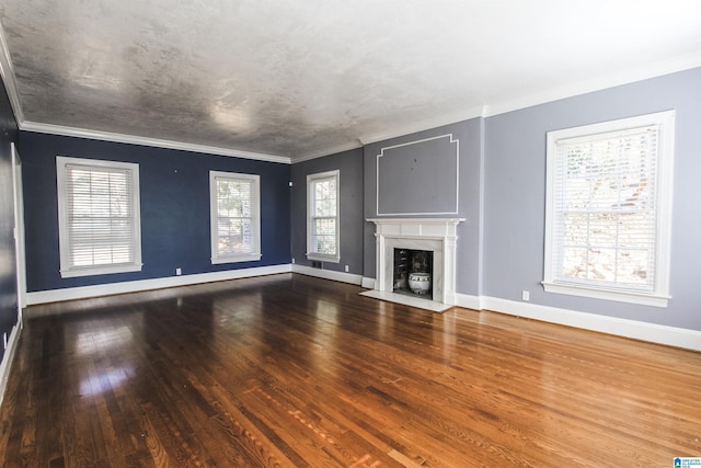 unfurnished living room featuring a fireplace with flush hearth, crown molding, baseboards, and wood finished floors