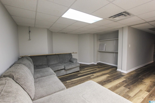 living area featuring a paneled ceiling, baseboards, visible vents, and dark wood-type flooring