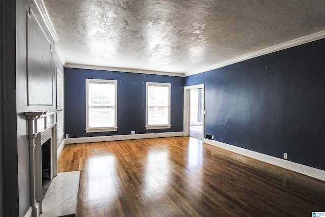 unfurnished living room with a textured ceiling, a fireplace, wood finished floors, baseboards, and ornamental molding