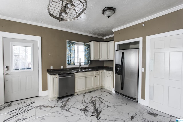 kitchen featuring dark countertops, appliances with stainless steel finishes, ornamental molding, a sink, and a textured ceiling