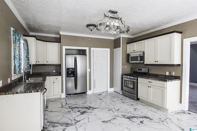 kitchen with dark countertops, appliances with stainless steel finishes, marble finish floor, white cabinetry, and a sink