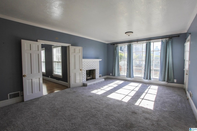 unfurnished living room featuring ornamental molding, carpet, a brick fireplace, and visible vents