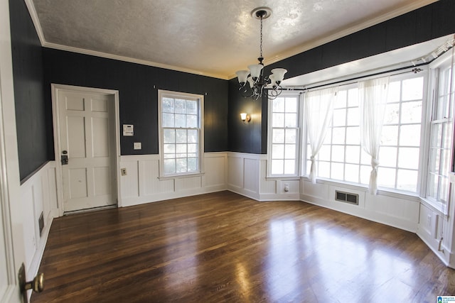 unfurnished dining area with ornamental molding, dark wood-style flooring, visible vents, and a chandelier