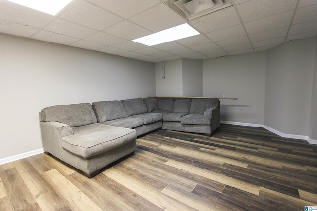 living area featuring a drop ceiling, wood finished floors, and baseboards