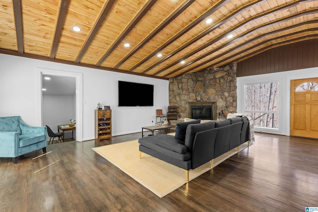 living room featuring lofted ceiling with beams, wooden ceiling, a fireplace, and dark wood-style floors