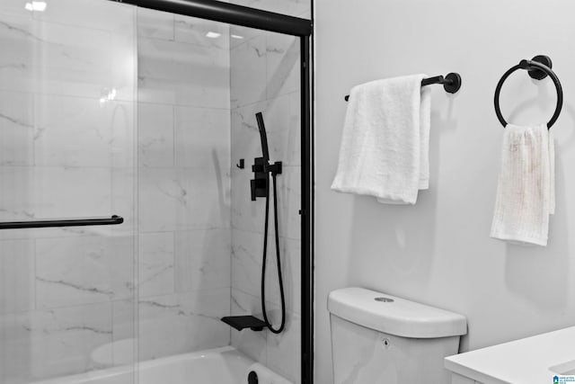 bathroom with shower / bath combination with glass door and toilet