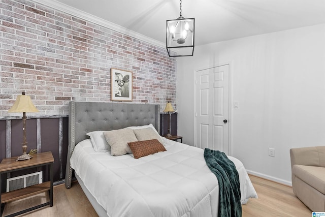 bedroom featuring light wood-style flooring, visible vents, baseboards, and ornamental molding