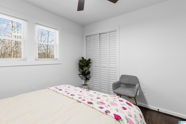 bedroom with ceiling fan, a closet, dark wood finished floors, and baseboards