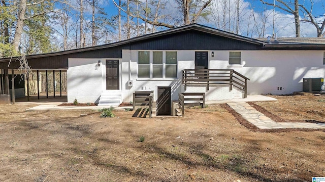 rear view of property featuring entry steps, crawl space, central air condition unit, and brick siding