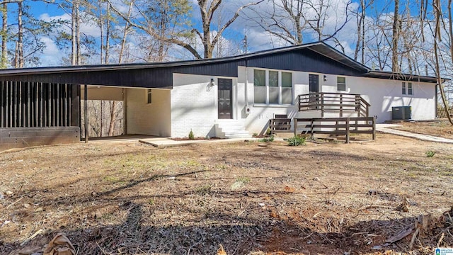 view of front of property featuring a carport, cooling unit, and brick siding