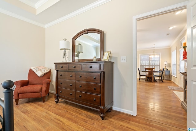 sitting room featuring ornamental molding, baseboards, a notable chandelier, and light wood finished floors