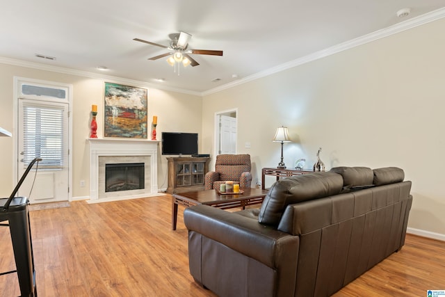 living room featuring ornamental molding, visible vents, and light wood-style flooring