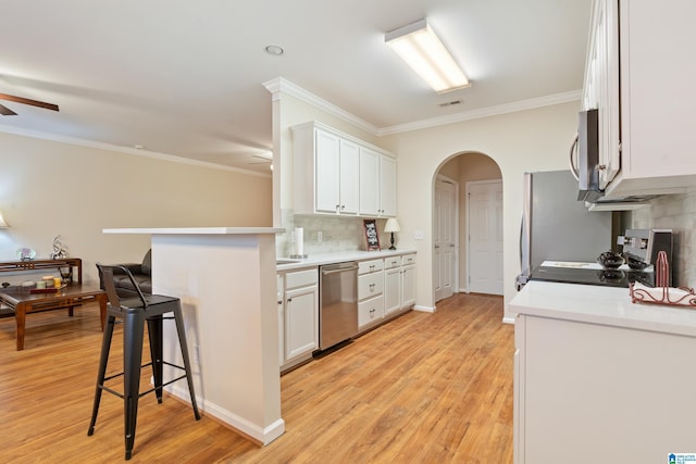 kitchen featuring visible vents, appliances with stainless steel finishes, arched walkways, and a ceiling fan