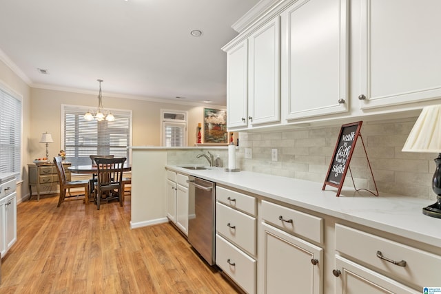 kitchen featuring light countertops, light wood-style flooring, stainless steel dishwasher, ornamental molding, and a sink