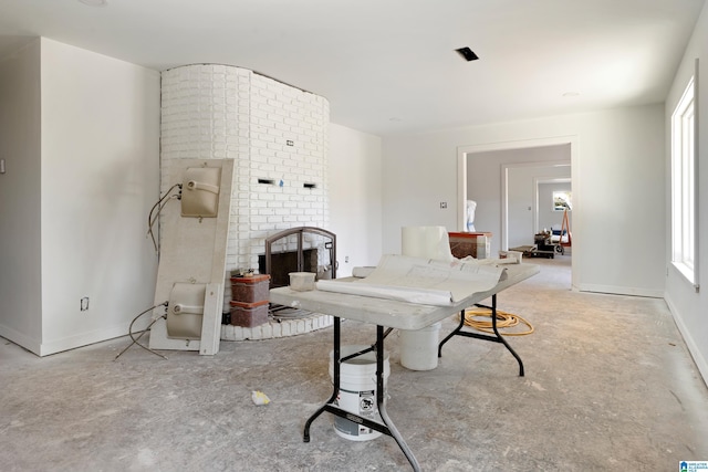 rec room featuring concrete floors, a fireplace, and baseboards