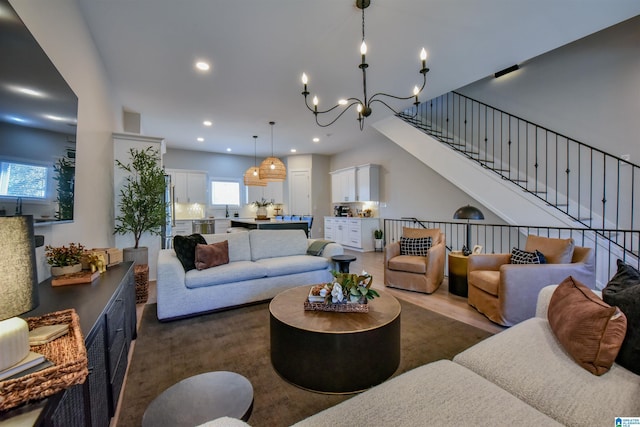 living area featuring recessed lighting, dark wood-style flooring, a notable chandelier, and stairway