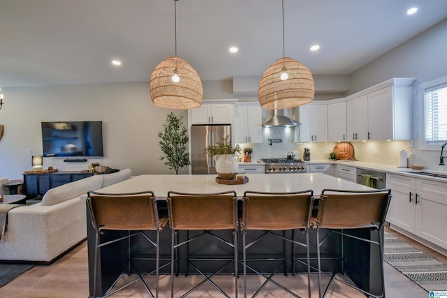 kitchen with appliances with stainless steel finishes, a center island, light countertops, and white cabinetry