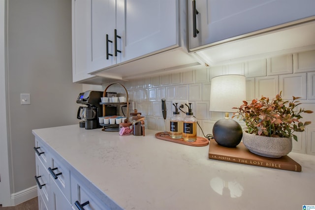 kitchen featuring light stone counters and white cabinets