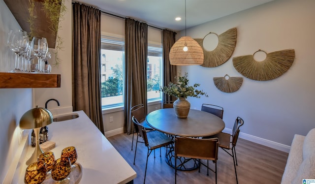 dining area with baseboards and wood finished floors