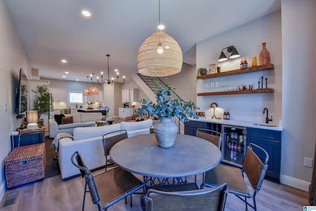 dining space featuring light wood-type flooring, wine cooler, wet bar, and recessed lighting