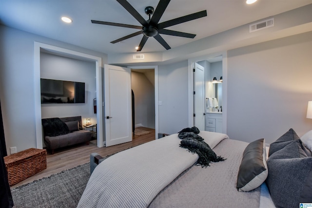 bedroom with recessed lighting, connected bathroom, visible vents, and light wood-style floors