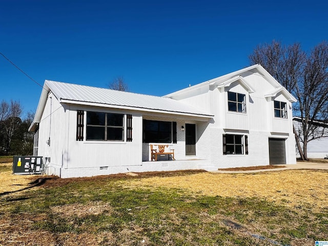 view of front of property featuring brick siding, a front yard, crawl space, metal roof, and a garage