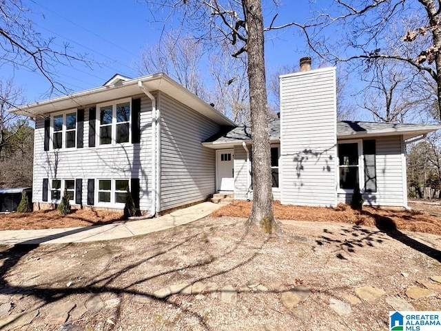 view of front of property with driveway and a chimney