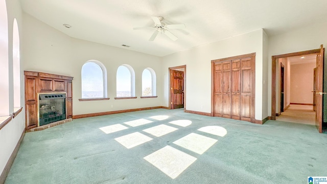 interior space featuring ceiling fan, light carpet, a fireplace, visible vents, and baseboards