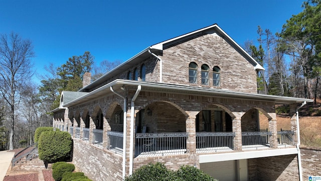 view of property exterior featuring a garage, brick siding, and a chimney