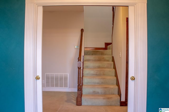 staircase featuring visible vents and carpet flooring