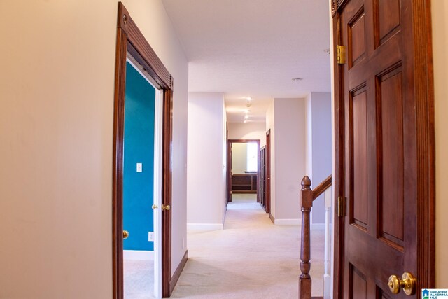 corridor featuring light carpet and baseboards