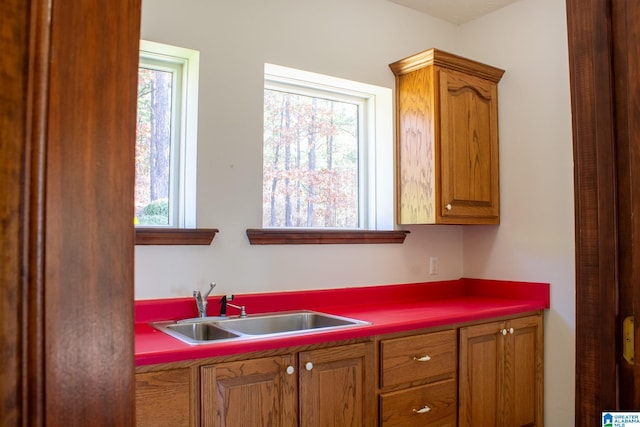 kitchen with dark countertops, a sink, and brown cabinets