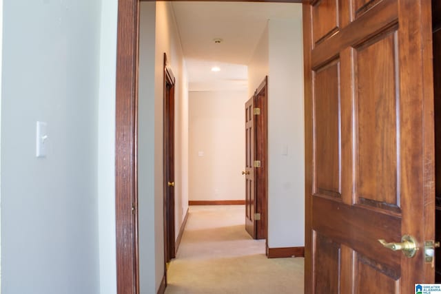 corridor featuring recessed lighting, light carpet, and baseboards