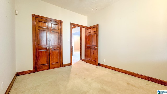 unfurnished bedroom with light carpet and baseboards