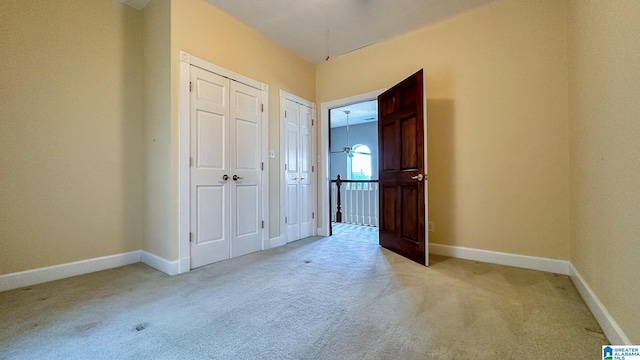 interior space with baseboards and light colored carpet