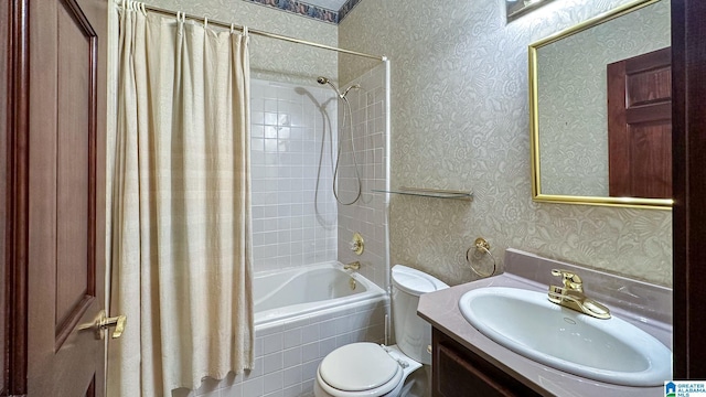 full bathroom with tiled shower / bath, toilet, vanity, and wallpapered walls