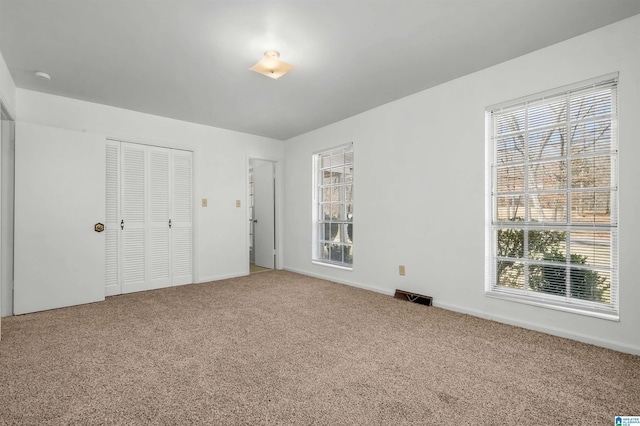 unfurnished bedroom featuring carpet, a closet, and visible vents