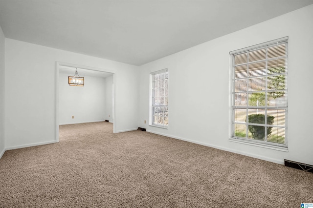 carpeted spare room with visible vents and baseboards