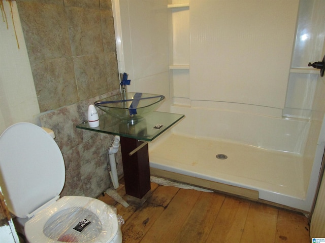 full bathroom with wood finished floors, walk in shower, and toilet