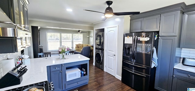 kitchen featuring white microwave, black fridge with ice dispenser, light countertops, stacked washer and clothes dryer, and glass insert cabinets