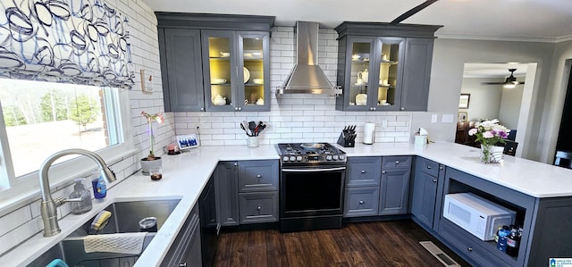 kitchen featuring gas range, glass insert cabinets, and light countertops