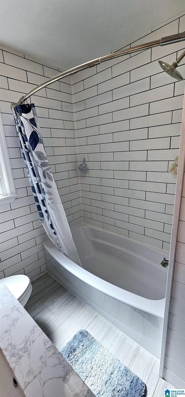 bathroom with toilet and shower / bath combo