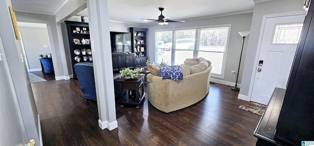 living room with ornamental molding, dark wood finished floors, a ceiling fan, and baseboards