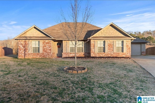 view of front facade with a front yard, brick siding, fence, and driveway