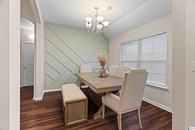 dining space featuring dark wood-style floors, arched walkways, a notable chandelier, visible vents, and baseboards