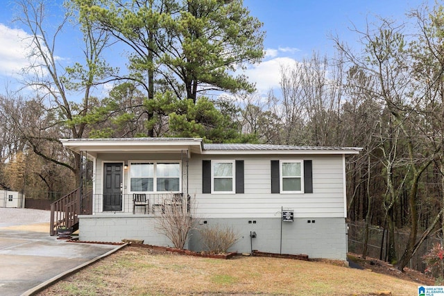 view of front facade featuring metal roof, crawl space, and fence